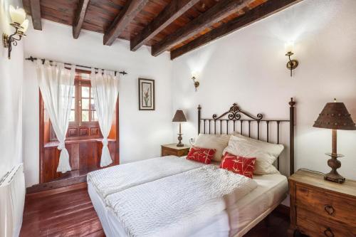 塔科龙特Finca Los Viñedos Casa Rural的一间卧室配有一张带红色枕头的床
