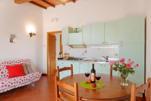 圣多纳托因弗伦萨诺Podere I Sorbi的厨房以及带1张带1瓶葡萄酒的桌子的用餐室。