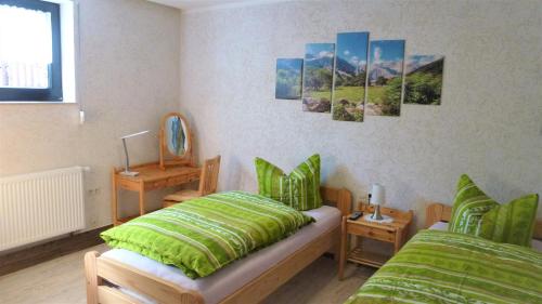 上隆维茨Ferienwohnung Oberlungwitz的一间卧室设有两张单人床和一面镜子