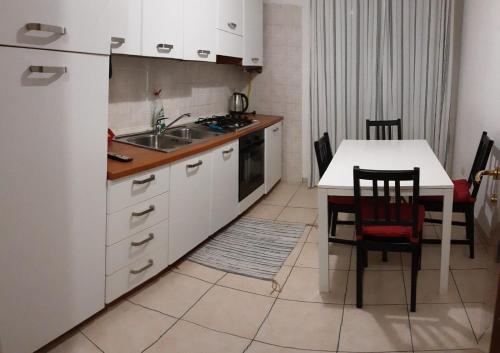 帕多瓦Locazione Menini - Camere zona stazione的厨房配有白色冰箱和桌椅