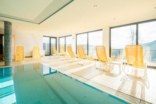 博伦多夫索娜伯格瓦尔德酒店的一个带黄色椅子和一排最适合游泳的游泳池