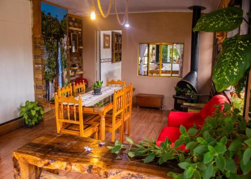 乌鲁比西Hospedagem Rural Recanto do Riacho的一间带桌子和红色沙发的用餐室