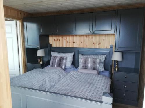 SinnesFerienhaus Fjellblikken的一间卧室配有一张带蓝色橱柜的床。
