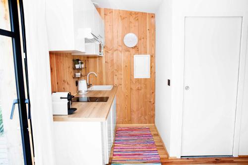 雷日卡普费雷Beach House的一间小厨房,配有白色的橱柜和地毯