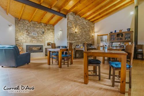 CaçarelhosCurral D Avó Turismo Rural & SPA的客厅配有桌子和壁炉