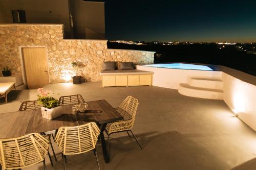 弗通Amer Villa Santorini with outdoor hot tub的一个带桌椅的庭院和一个游泳池