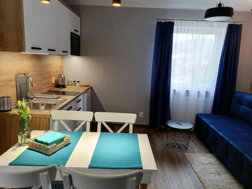 斯克拉斯卡波伦巴Willa pod lasem的客厅配有桌子和蓝色沙发