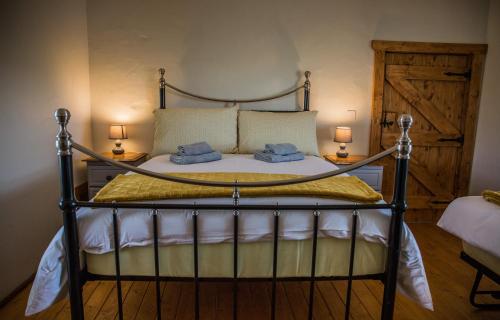 DromaraDans Wee Cottage Slieve Croob Dromara Castlewellan Newcastle的一间卧室配有一张带两个枕头和两个灯的床。
