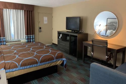 纽波特纽斯Super 8 by Wyndham Newport News的一间酒店客房,配有一张床、一台电视和一面镜子