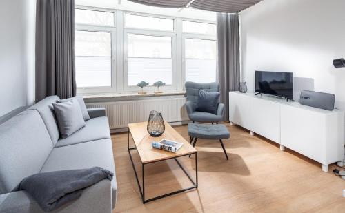 诺德奈Strandloft Drei Norderney的带沙发、电视和桌子的客厅