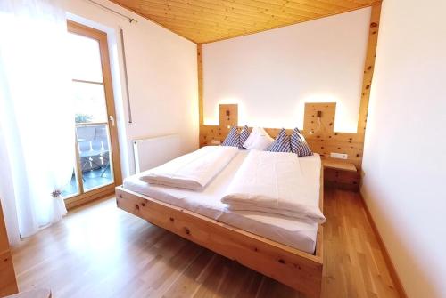 梅拉诺Appartements Grumserhof的一张大床,位于带大窗户的房间里