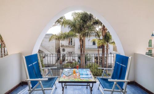 伊斯基亚Hotel Terme Oriente - Beach & SPA的阳台设有一张桌子和椅子,阳台设有拱门