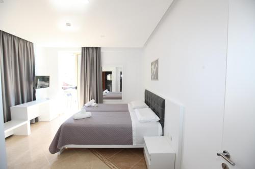 萨兰达Nika Hotel的白色的卧室设有床和窗户