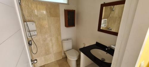 万隆Villa Marbelice的一间带卫生间、水槽和镜子的浴室