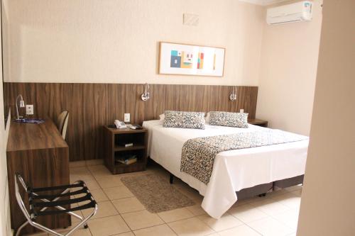 普雷图河畔圣若泽利维埃拉酒店的一间卧室设有一张床和木墙