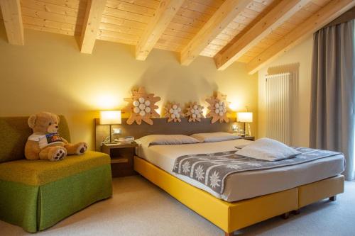 图恩诺图弗木屋酒店 - 山湖的一间卧室配有一张床,椅子上配有泰迪熊