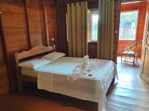 Careiro亚马逊金龙鱼小屋旅馆的一间卧室配有一张带白色床罩的床