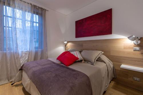 日科德尔格尔福迪艾斯Apartment Acero Rosso的一间卧室配有一张床和一个带红色枕头的窗户