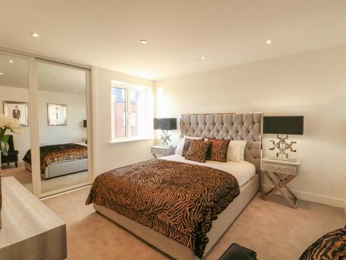 韦茅斯Harbourside Haven Apartment 3的一间卧室配有一张特大号床和一面镜子