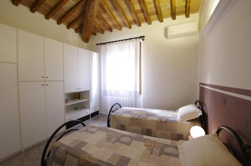巴尔贝里诺瓦尔德尔萨Il Torrino的小房间设有两张床和窗户