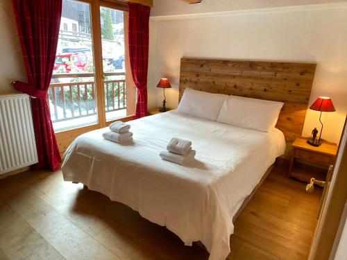 梅杰夫Chalet Roseau的一间卧室配有一张床,上面有两条毛巾