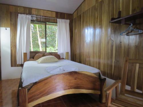Caño NegroPoponjoche Lodge Caño Negro的一间卧室配有一张木墙床