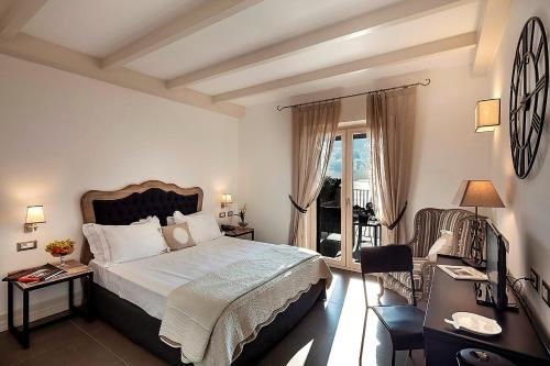 伊斯基亚波焦安蒂科庄园酒店的一间带大床的卧室和一个阳台