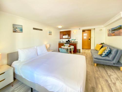 檀香山Bamboo Hotel Charm, Moments from the Sandy Shore的卧室配有一张白色的大床和一张沙发。