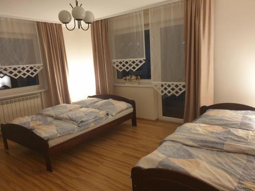 PoniceNoclegi w gorcach的带2扇窗户的客房内的2张床