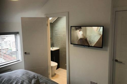克利索普斯Oole 2 bed & en-suites house with parking near beach的一间卧室设有浴室,墙上配有电视。