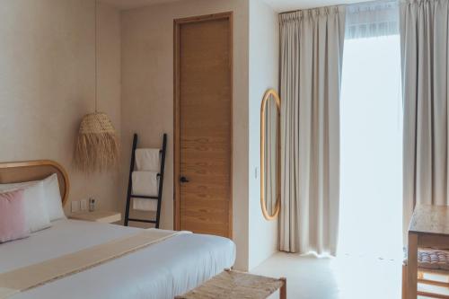 奥尔沃克斯岛Casa Peregrino Holbox的一间卧室设有一张床和一个窗口