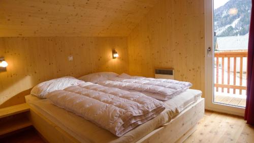 上陶恩特里本斯特恩木屋的木墙客房的一张床位