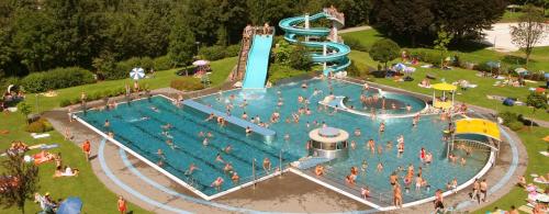 齐勒河谷采尔阿帕特湖迪斯公寓的公园里一个带水滑梯的大型游泳池