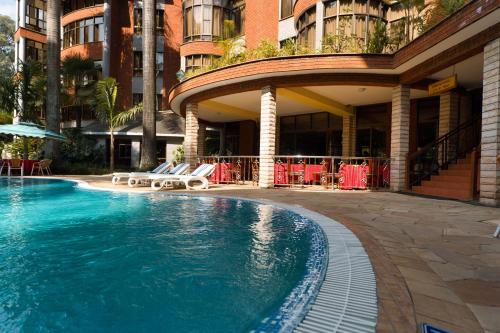 阿鲁沙Kibo Palace Hotel Arusha的大楼前的游泳池