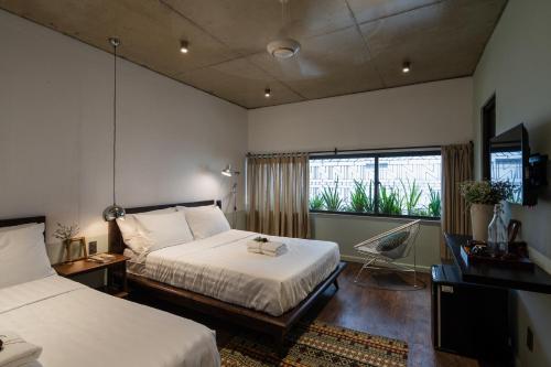 大叻The Note Dalat的酒店客房设有两张床和窗户。