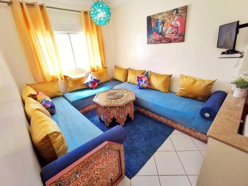 迈尔提勒Reta-Inn Martil Beach的客厅配有蓝色的沙发和桌子
