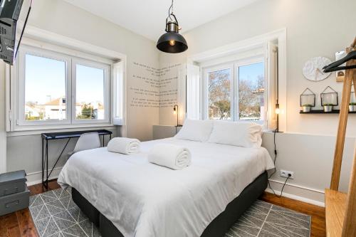 埃斯托利尔Sweet Spot @ Beach的卧室配有一张带白色床单和窗户的大床。