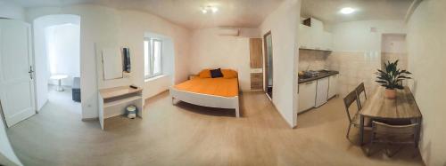 斯潘卡卢卡Studio Apartments & Rooms Lela的一间卧室配有一张床,厨房配有桌子