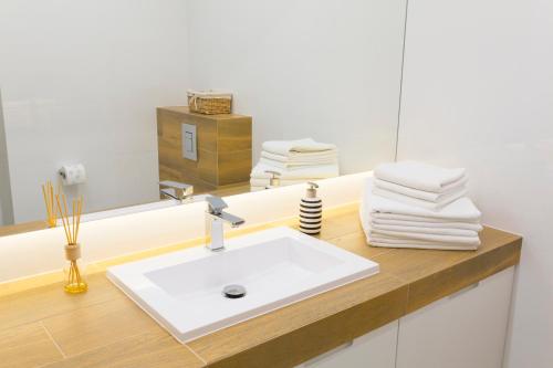 克拉科夫Chopin Apartments的浴室配有盥洗盆、镜子和毛巾