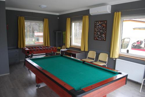 ApostagCasa Napsugár Panzió的配有台球桌和两把椅子的房间