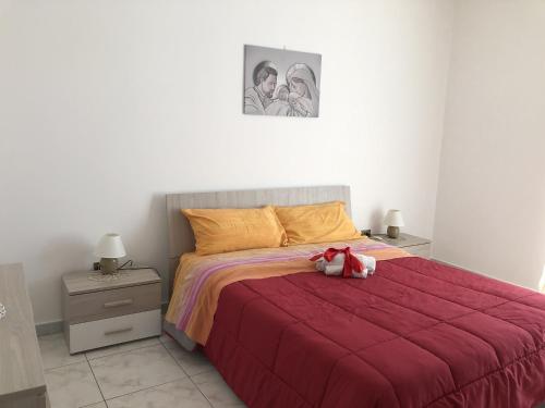 孔韦尔萨诺Cupersanum B&B的一间卧室,配有一张红色的床,上面有泰迪熊