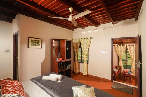 瓦亚纳德Zostel Homes Wayanad, Thirunelly的一间卧室配有一张床和吊扇