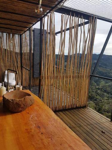 麦德林Glamping La Montaña Sagrada的客房设有木桌和大窗户。