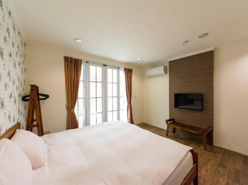 南湾垦丁恋南湾 的卧室配有一张白色大床和电视。