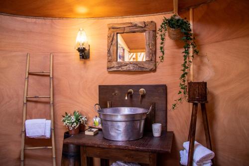 阿夏诺2 CUORI E 1 YURTA Glamping in Tuscany - Adults Only的一个带镜子的桌子上的桶的浴室