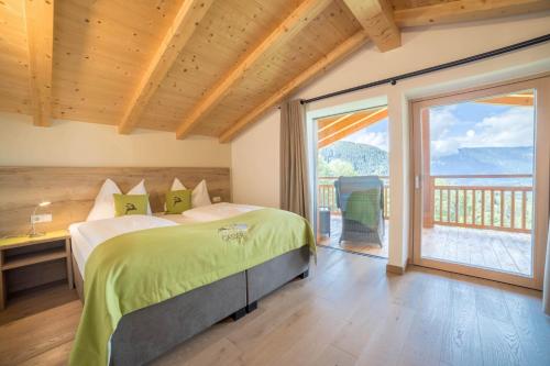 麦尔迪娜Gasserhof Chalets的一间卧室设有一张床和一个大窗户