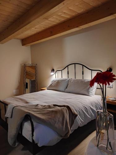阿尔梅诺Le Farfalle di Armeno的一间卧室设有一张大床和一个花瓶