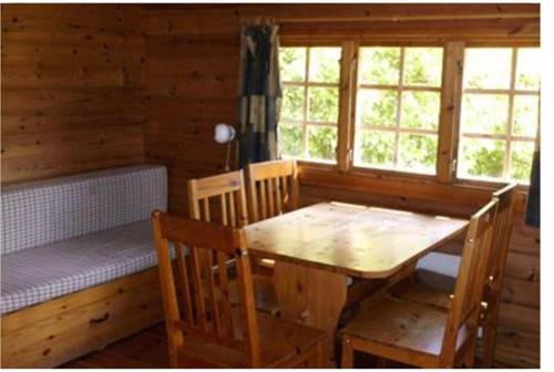 VesløsBygholm Camping的小屋内带桌子和长凳的用餐室