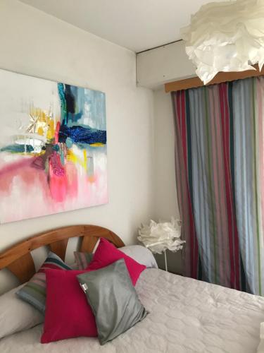 比亚里茨Apartment Prado的卧室配有一张床,墙上挂有绘画作品