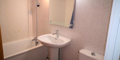卢贝新城Résidence Cap Azur Appartement 218的一间带水槽、卫生间和镜子的浴室